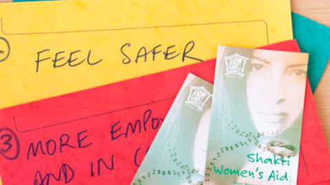 Cards and leaflets laid out for Shakti Women's Aid workshop
