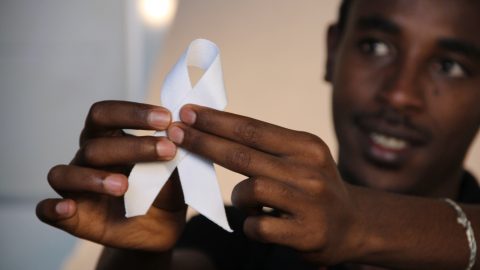 Close up of the White Ribbon held by a member of the Maryhill Integration Network Men's Group