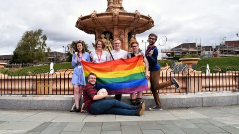 LGBTQI activists group with racquets and rainbow flag